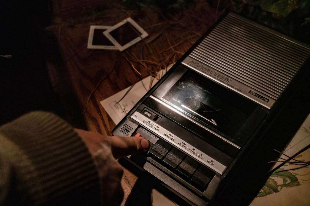 A person pressing play on a cassette tape player
