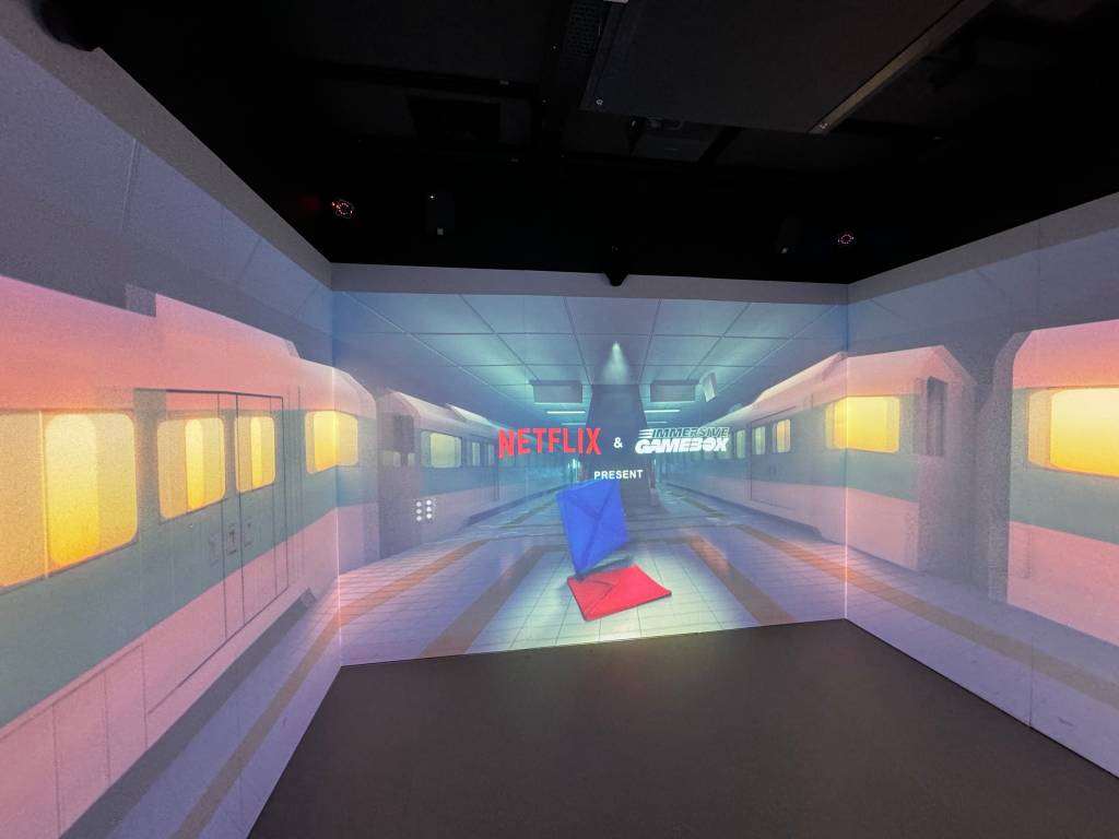 The three walls show a wraparound subway video with the logos for Netflix and Immersive Gamebox