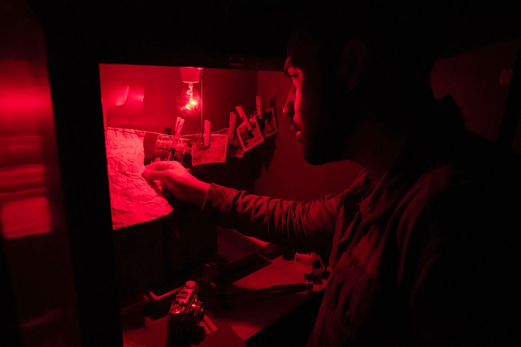 A man reads instructions under a red light
