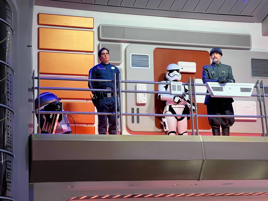 A droid, human (Sammie), stormtrooper, and Croy on the raised atrium