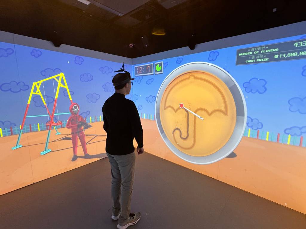 Adrian faces a screen where the shape of an umbrella is being etched out of a circular candy