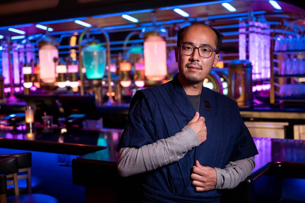 Adrian in Jedi training uniform in a neon-lit bar
