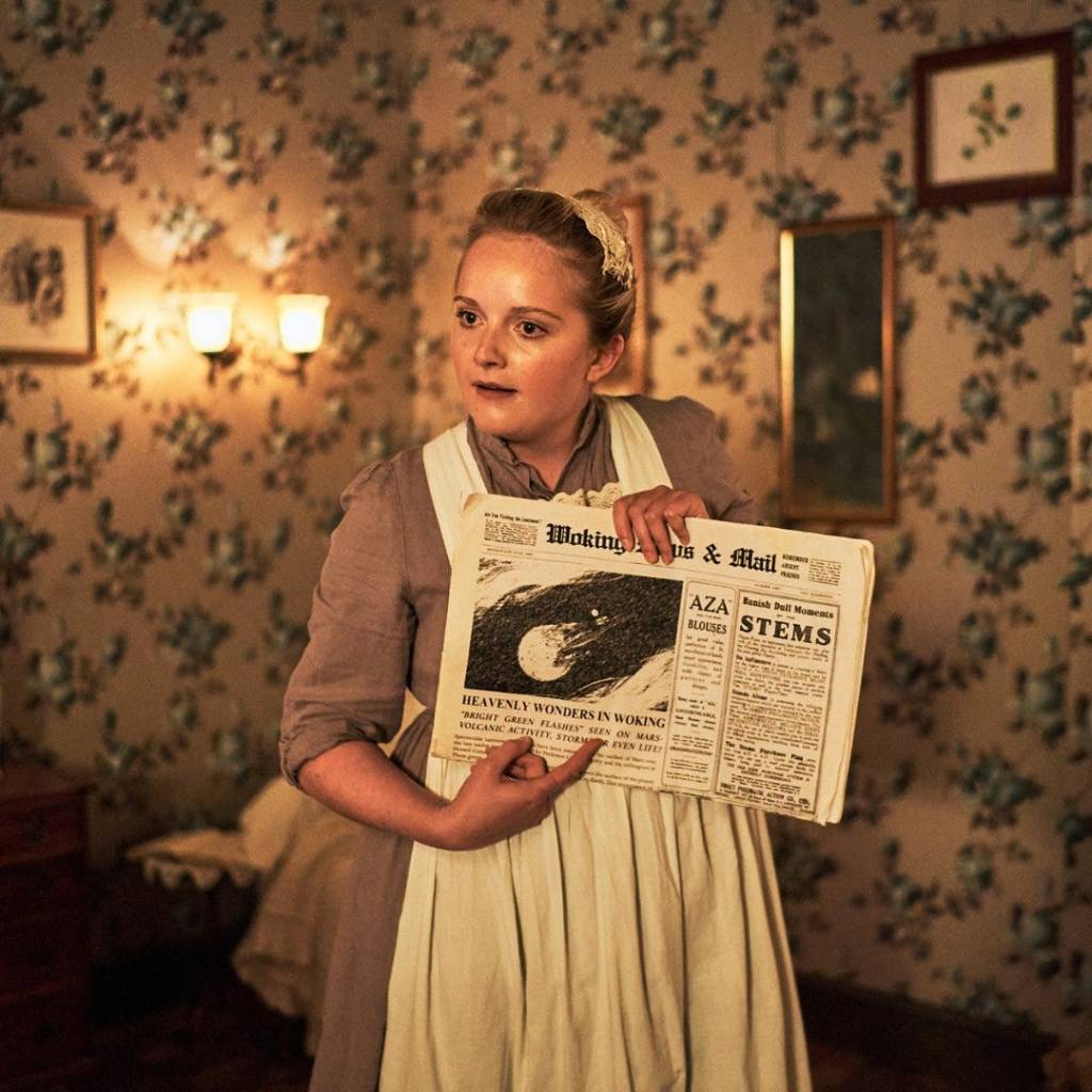 A maid holds up a newspaper with the headline "Heavenly Wonders in Woking"