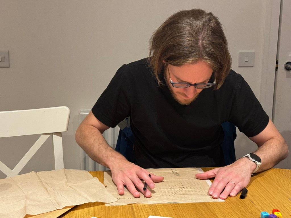 A person completing a wordsearch using tracing paper