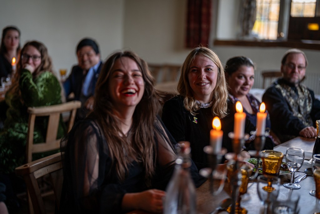 A group of people seated at dining tables laugh