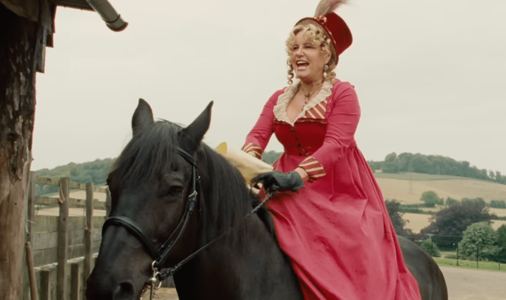 A woman in a pink dress on horseback