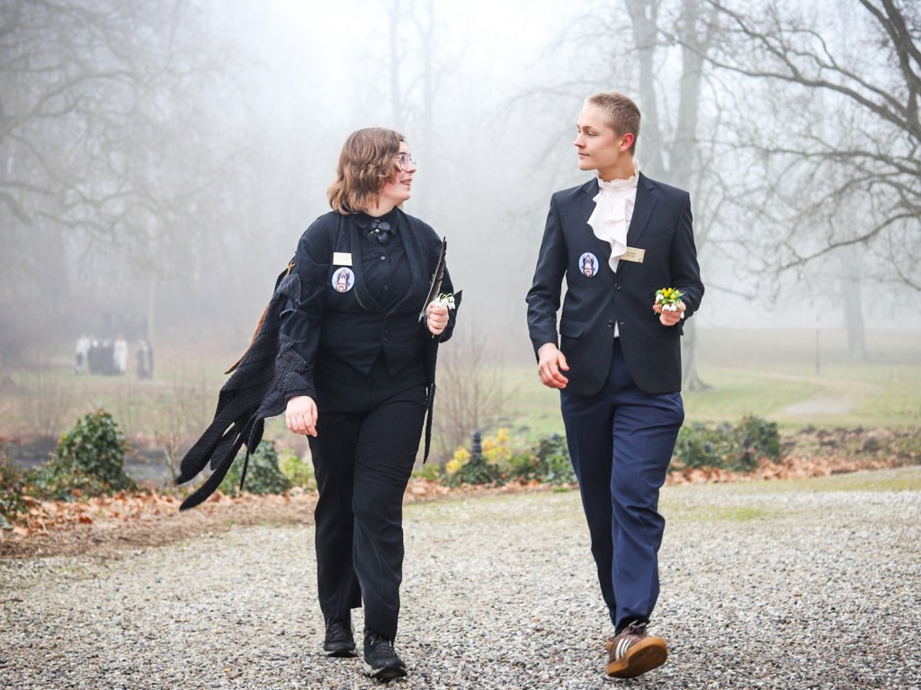 A pair of students outside, one dressed as a black bird