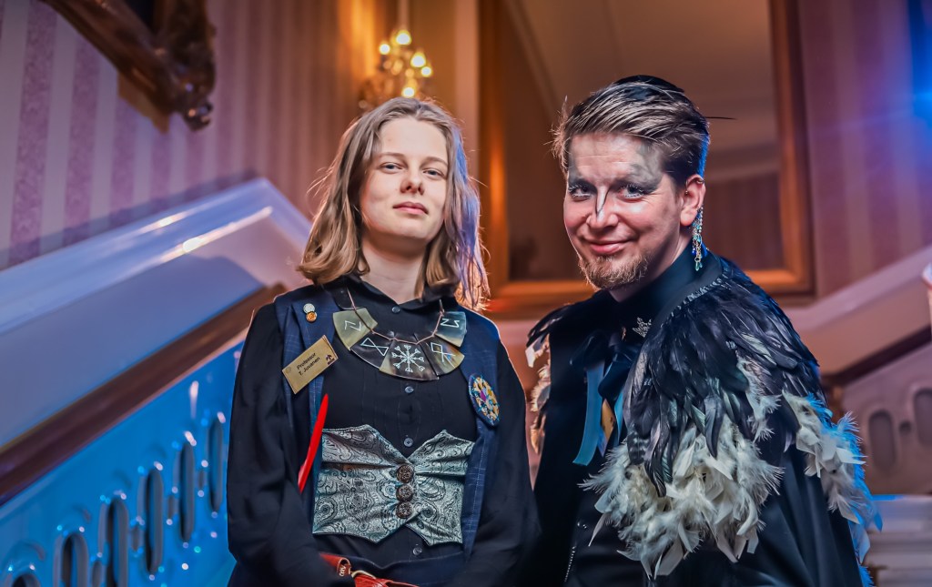 Two students posing, one in a bird costume/makeup